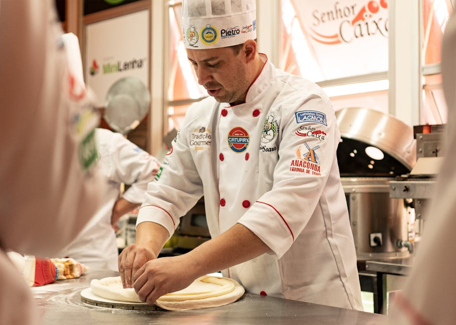 Chef kneading dough in a professional kitchen, showcasing culinary skills and uniform details.