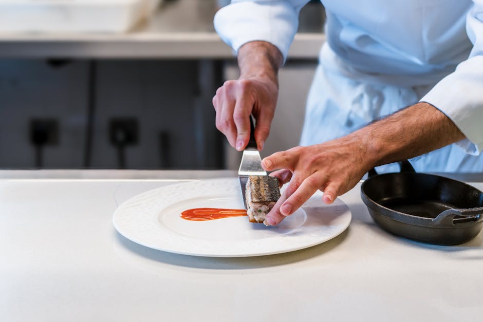Close-up of a chef plating a gourmet meal, showcasing culinary precision and artistry.